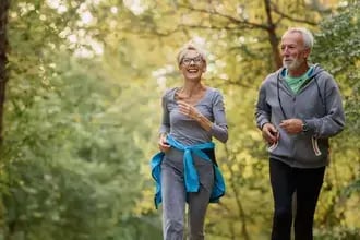 Cheerful active senior couple jogging